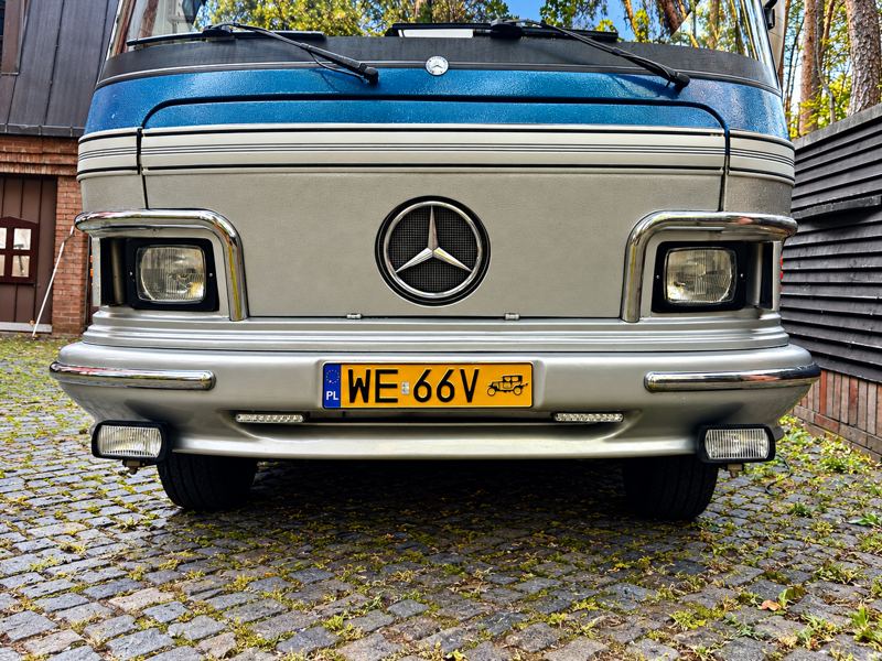 Przód kampera ze znakiem Mercedesa i tablicą